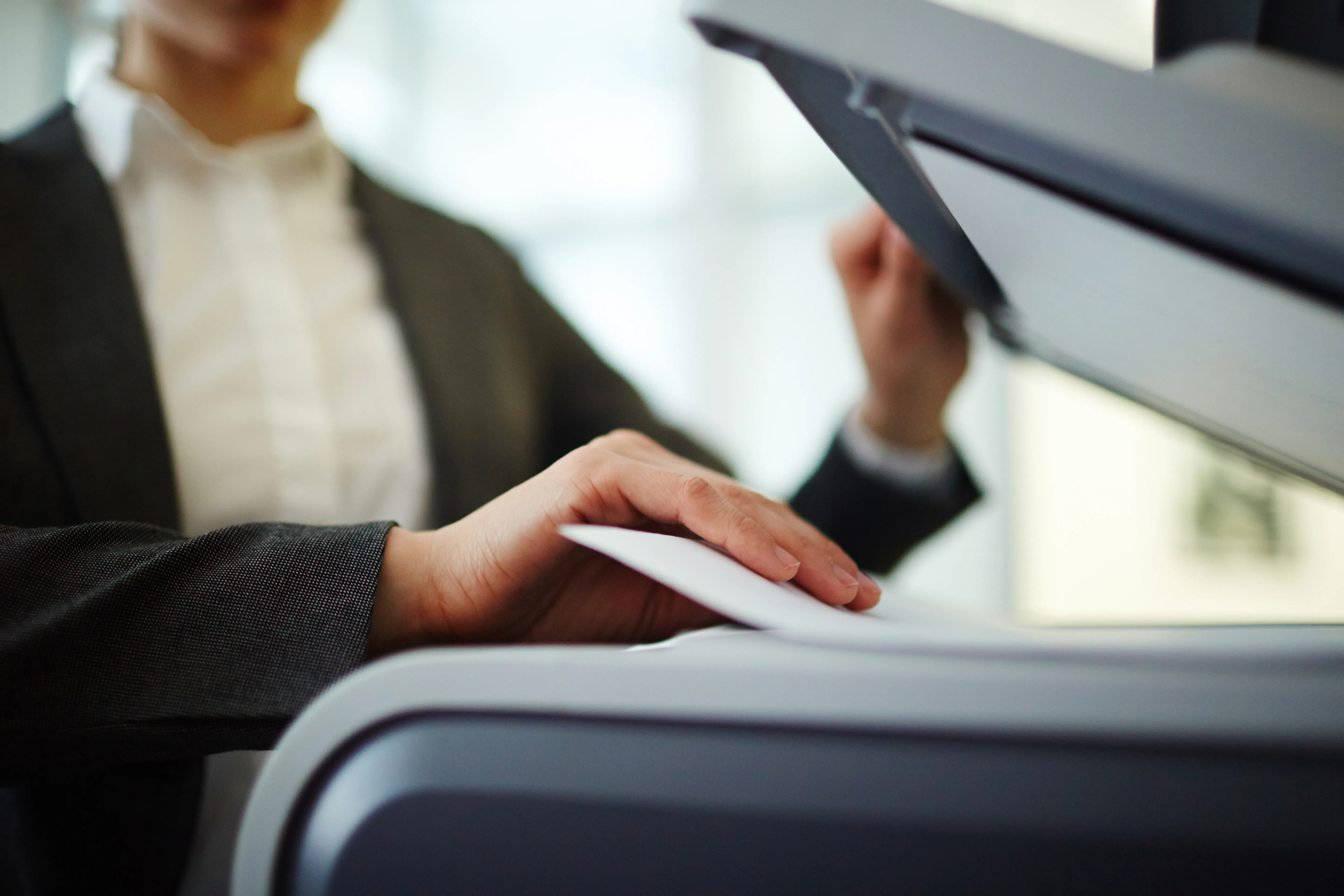 Office worker placing paper in a photocopier