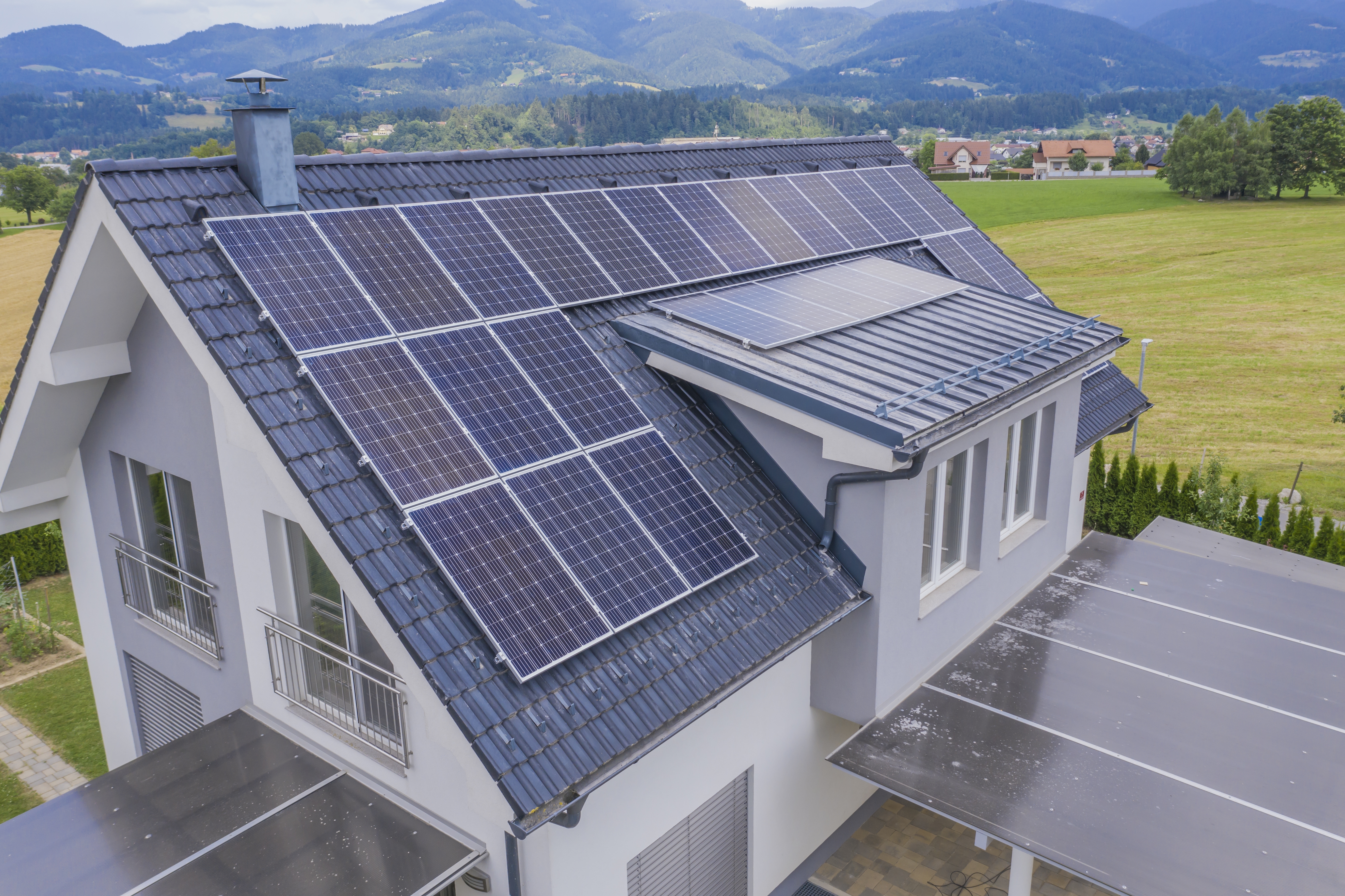 Solar panels covering the roof of a modern Irish home surrounded by green fields and hills